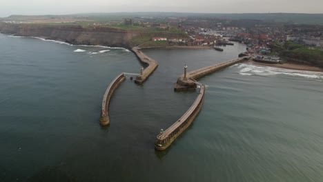 Luftpanorama-Des-Whitby-Harbour-East-Lighthouse-Und-West-Pier-In-North-Yorkshire,-England,-Vereinigtes-Königreich