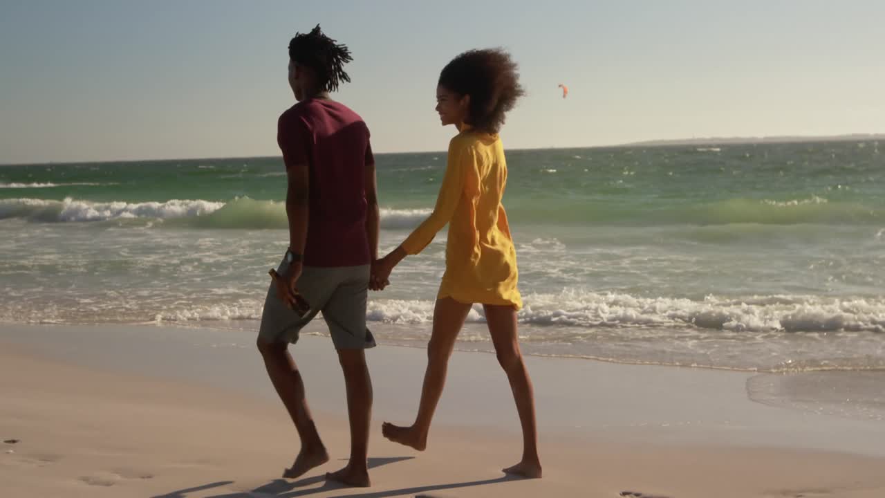 pareja caminando juntos en la playa 4k