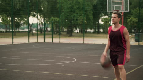 skillfull male basketball player dribbling ball against opposing defender, throwing ball into hoop and giving him a high five