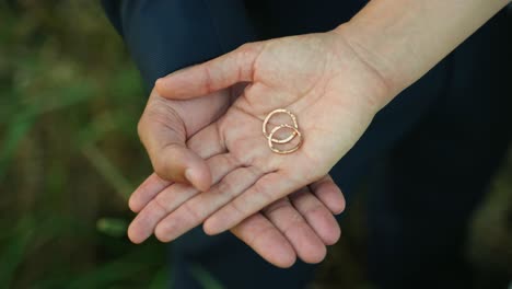 Bride-and-groom-holding-rings-in-their-hand-crossed