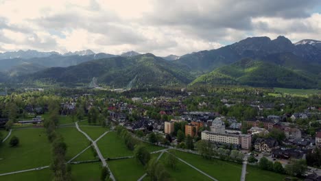 Sobrevuelo-De-Zakopane,-Polonia,-Un-Pueblo-Turístico-Con-Arquitectura-Goral-Tradicional-Cerca-De-Las-Montañas-Polacas-Tatra,-Tierras-De-Cultivo,-Bosques,-Pico-Giewont-Y-Gran-Salto-De-Esquí-Krokiew---Seguimiento-De-4k