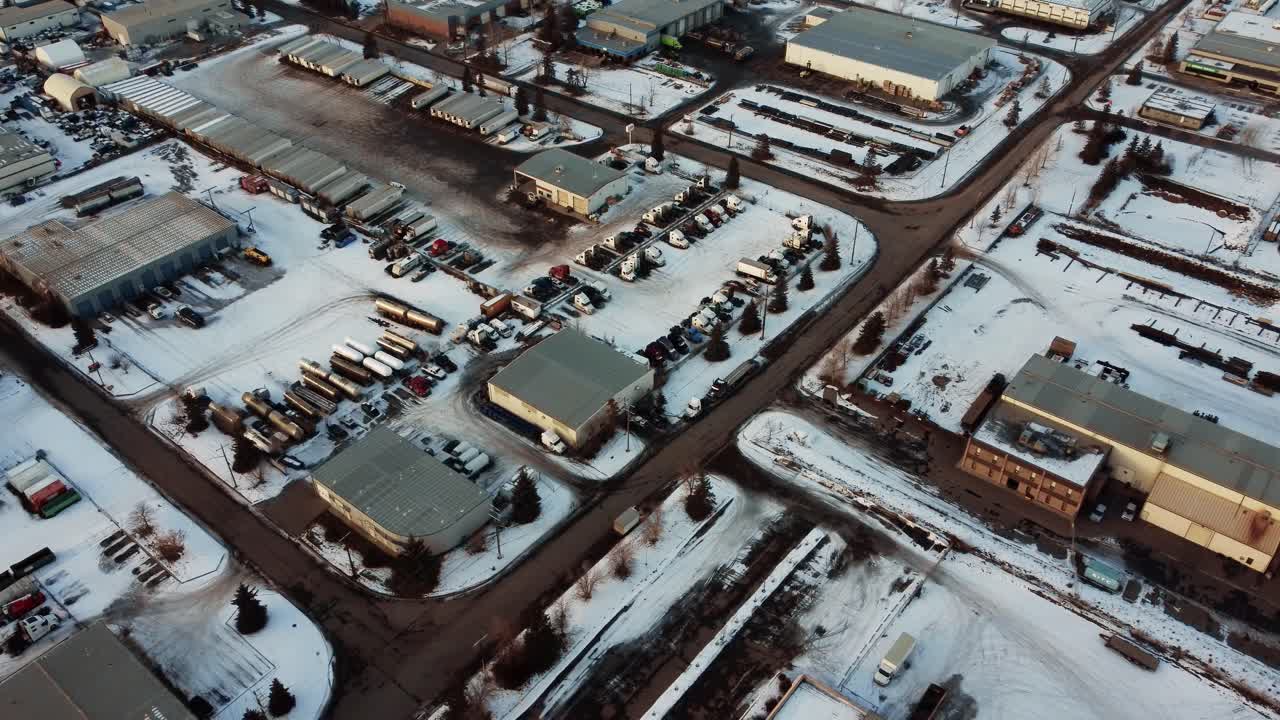 воздушный снимок грузовиков, прицепов и танков, припаркованных на открытом складе зимой