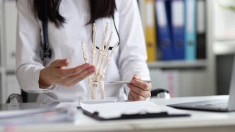 doctor explaining hand anatomy with skeleton model