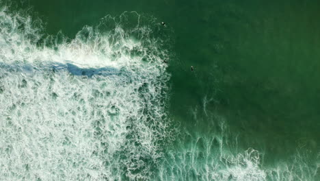 vista de arriba hacia abajo de los surfistas en la playa de la bahía de kogel en ciudad del cabo sudáfrica - toma aérea de drones