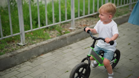 a child rides a bicycle joyfully, with a glimpse of a woman s leg riding a scooter beside him