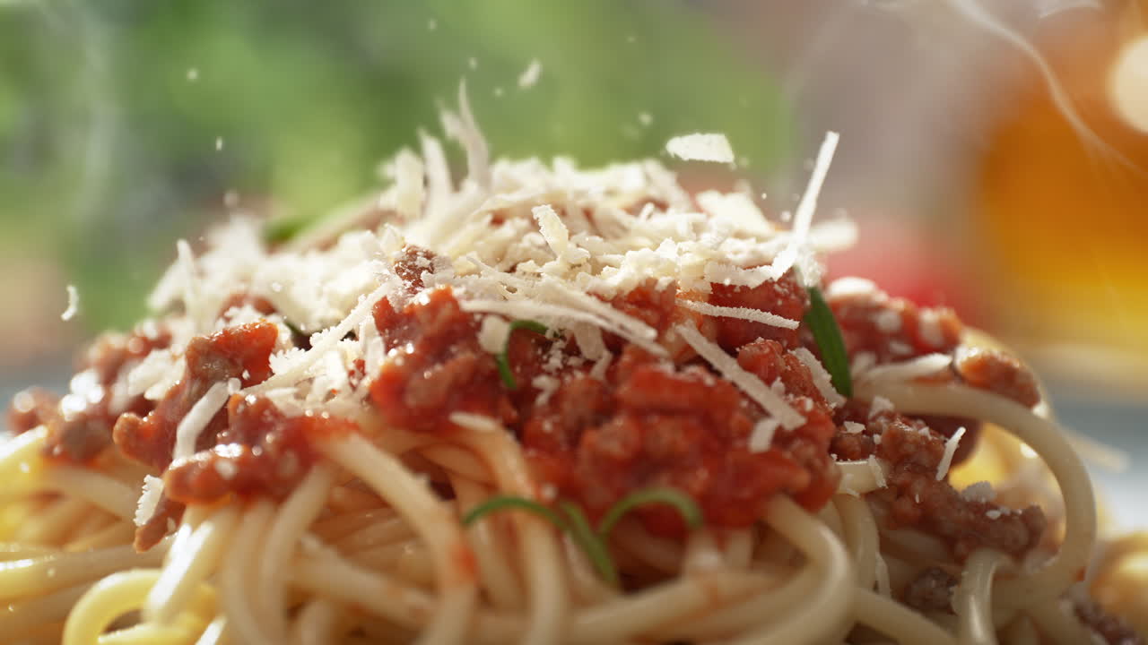 신선하게 준비 된 파르메잔을 뿌리며, 토마토 소스, 고기 및 로즈마리와 함께 스파게티 볼로네즈를 접시에 제공합니다.