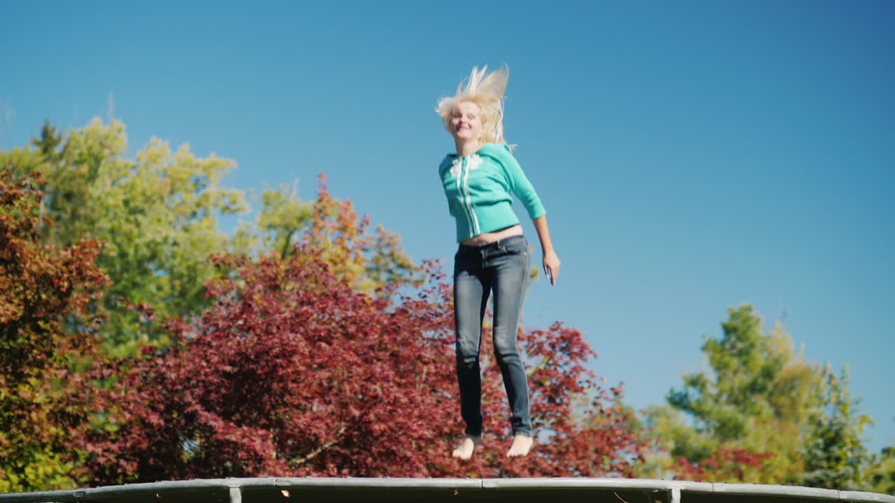 mujer de mediana edad salta en trampolín