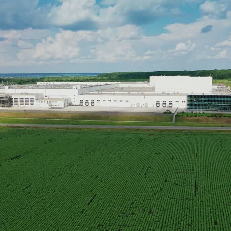 modern industrial plant in green fields. large territory of innovative factory among green nature in summer. aerial view. camera moves to the right.
