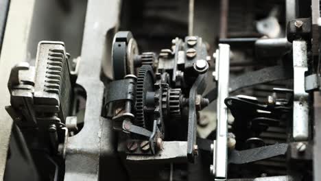 primer plano del mecanismo de una máquina de escribir mecánica antigua durante la operación de mecanografía
