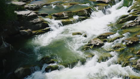 la corriente de un río limpio de montaña el agua fluye a través de grandes rocas