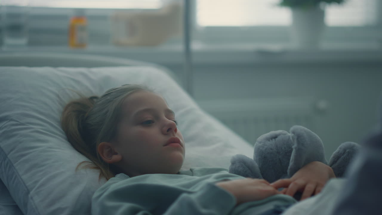 병원 침대에 누워 있는 소녀의 초상화, 포옹하는 장난감. 병원에서 환자를 방문하는 의사.