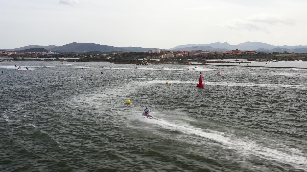 월드컵을 위해 훈련하는 동안 타오르는 빠른 제트 스키로 가득 찬 바닷물 위를 패닝하는 드론 이미지