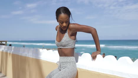 Woman-working-out-and-leaning-on-fence