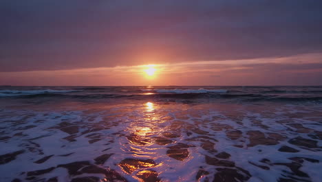 sunrise or sunset over the ocean with waves