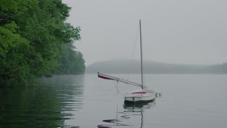 un velero en un lago en un día de niebla