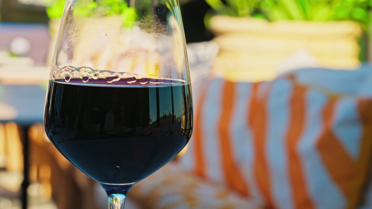 Primo piano di un bicchiere di vino rosso su un tavolo in una terrazza