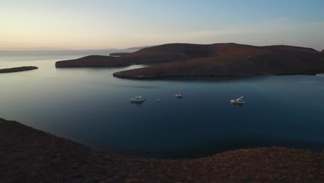 Toma-Aérea-De-Un-Grupo-De-Barcos-En-Una-Calma-Al-Atardecer,-Mar-De-Cortez,-Baja-California-Sur