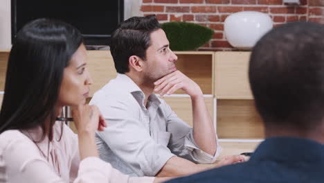 businessman with colleagues sitting in office meeting around table talking