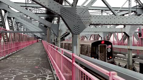 el tren del metro de nueva york pasa por el puente de williamsburg.