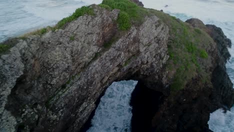 revealing aerial shot of sea caves in crescent head national park