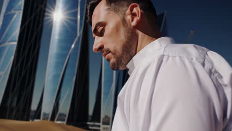 professional standing near gleaming eco friendly skyscrapers, highlighting sustainable urban design rising from desert landscape with solar reflective surfaces