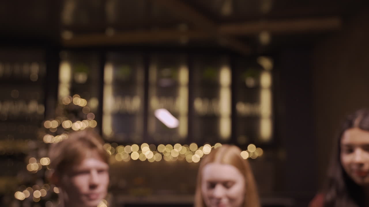 laq 카메라는 새해 파티에서 샴페인 잔을 들고 건배하는 친구들의 손에 초점을 맞춥니다.