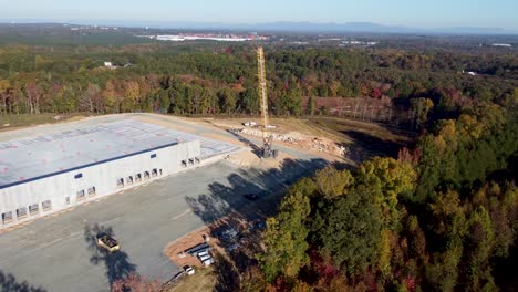 A-slow-orbiting-drone-shot-of-a-heavy-duty-crane-climbing-up-a-hill-to-another-location