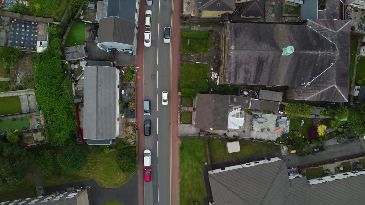 Tilted up drone shot of Skewen village along the main New Road cutting through dense housing area, Wales, United Kingdom, UK