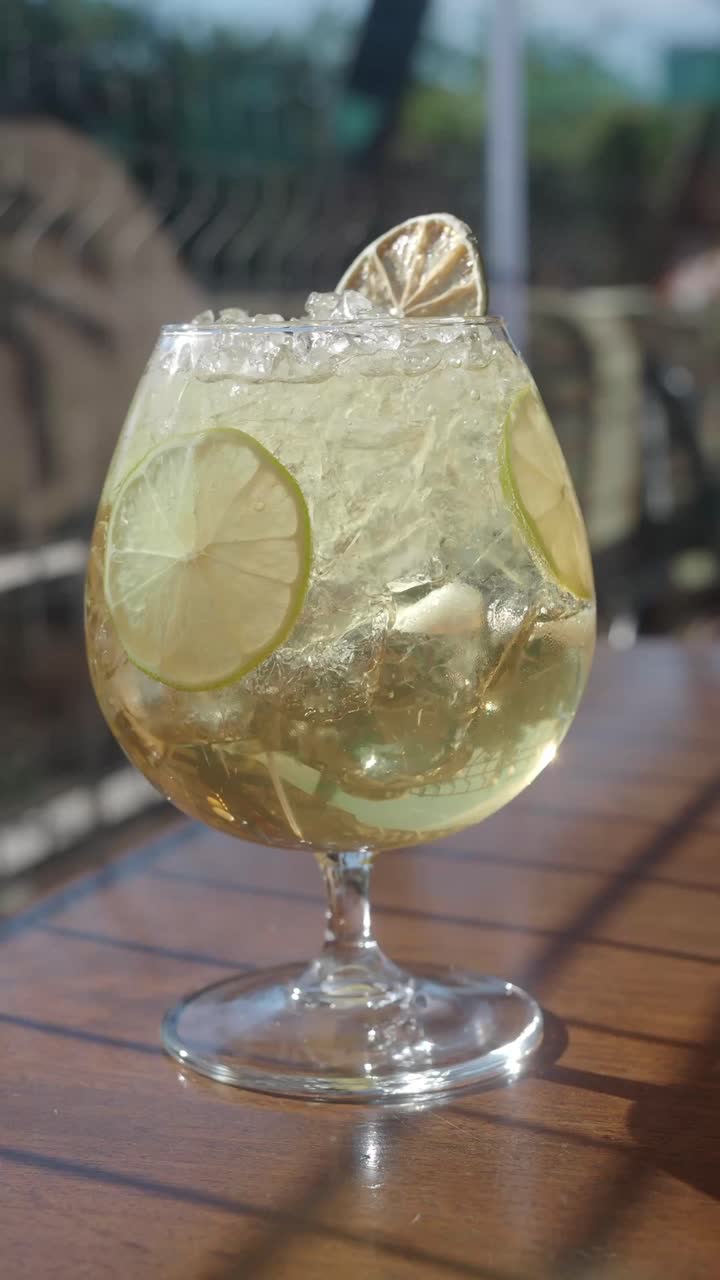 Mano che prende una bibita fredda e rinfrescante con lime e ghiaccio