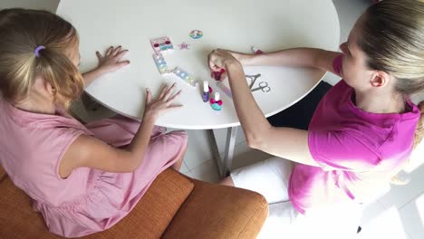 madre e hija pintando uñas