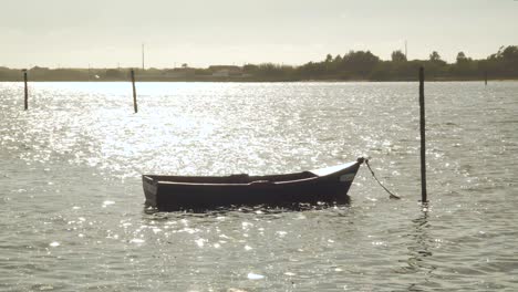 barco de madera de 4k amarrado en la ría de aveiro en el estuario del río vouga, barco balanceándose en la corriente del río
