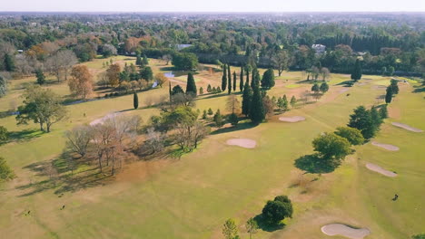 Antena---Trampas-De-Arena-Y-El-Green-En-Un-Club-De-Golf,-Plano-Amplio-Hacia-Adelante