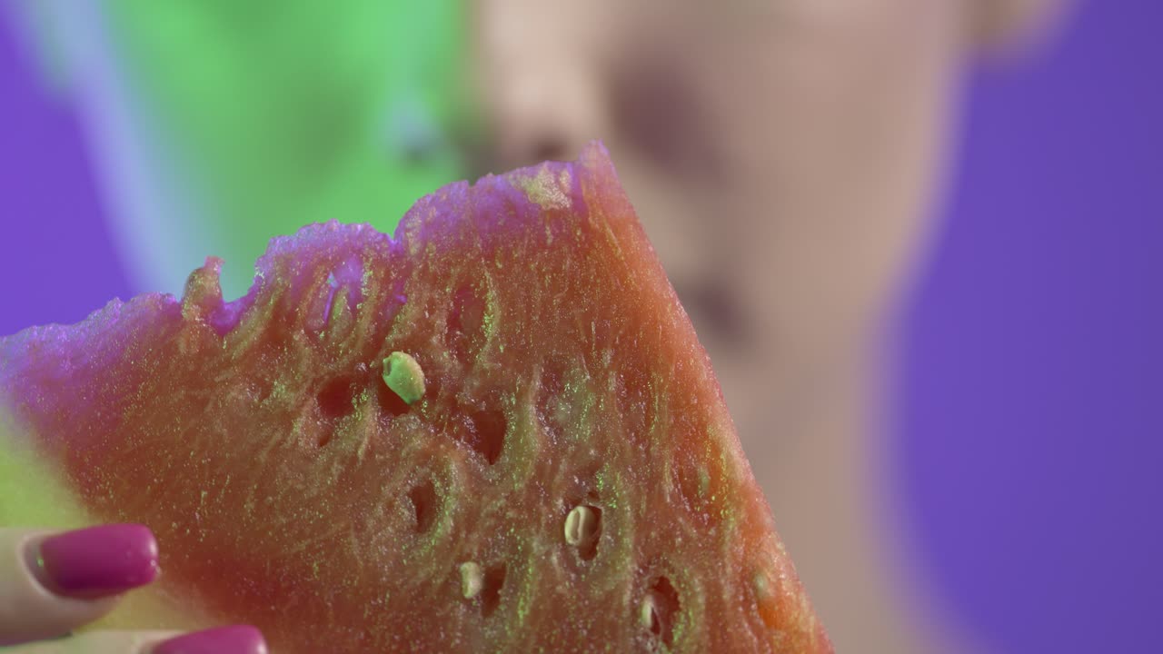 cerca de la cara y la boca de la mujer, comiendo sandía y lamendo los labios