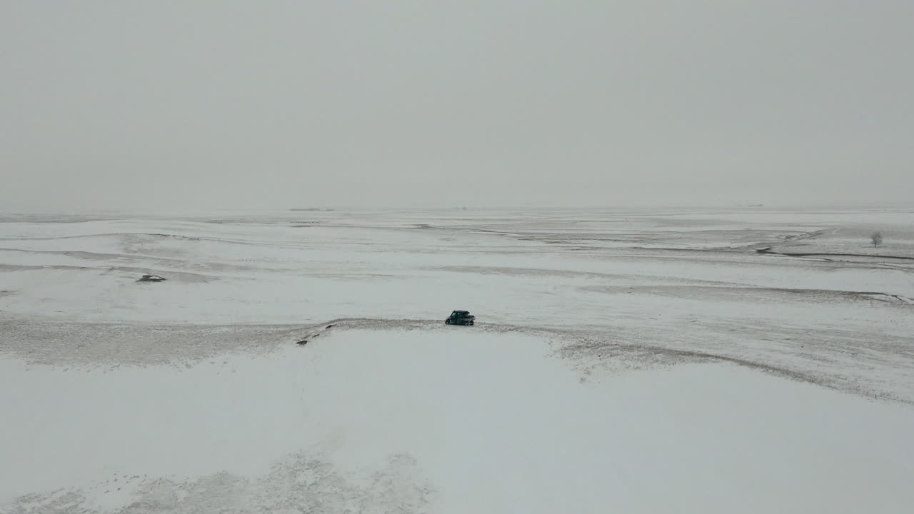 황량한 눈 덮인 대초원 한가운데에 나란히 있는 utv의 느린 궤도 공중, 4k