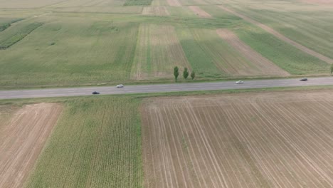 Felder-Auf-Dem-Land-Mit-Fahrzeugen-Und-LKWs,-Die-Tagsüber-Auf-Der-Autobahn-In-Rumänien-Fahren