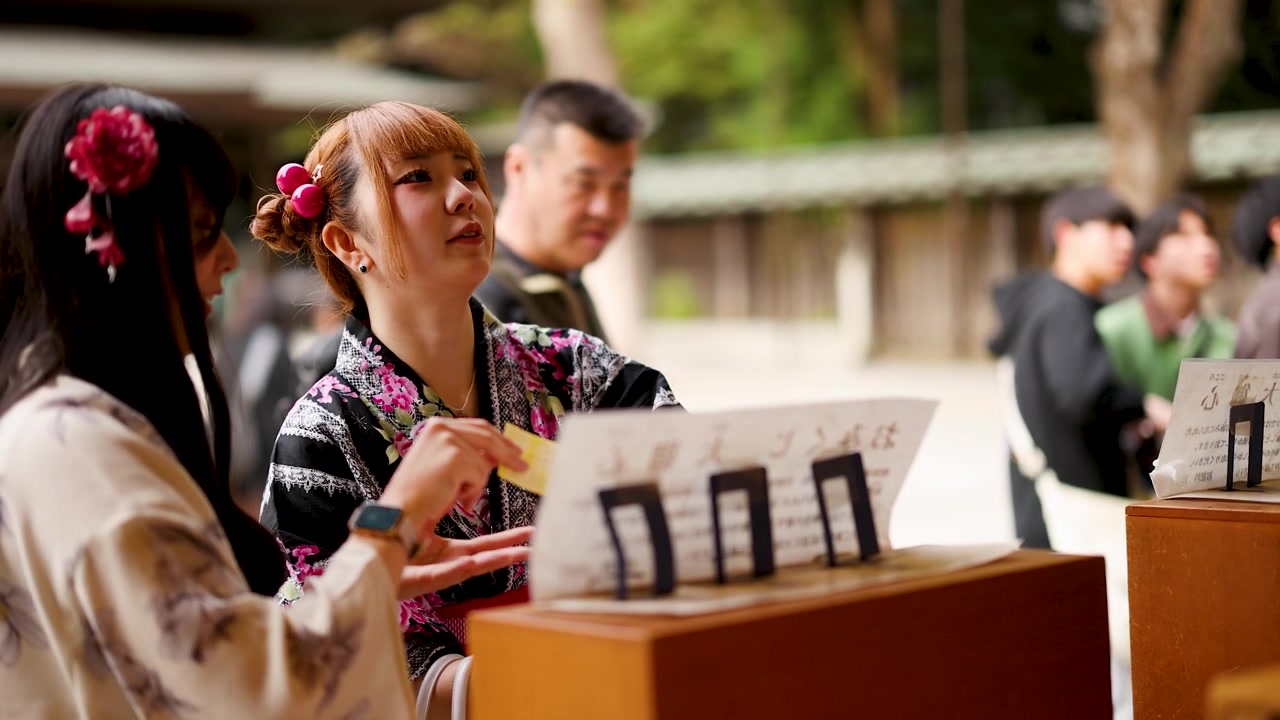 Dvě mladé ženy v kimonu navštěvující japonskou svatyni.