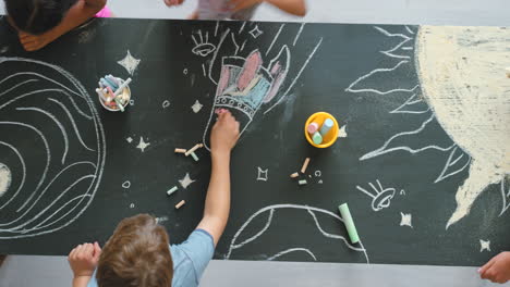 children drawing on a chalkboard