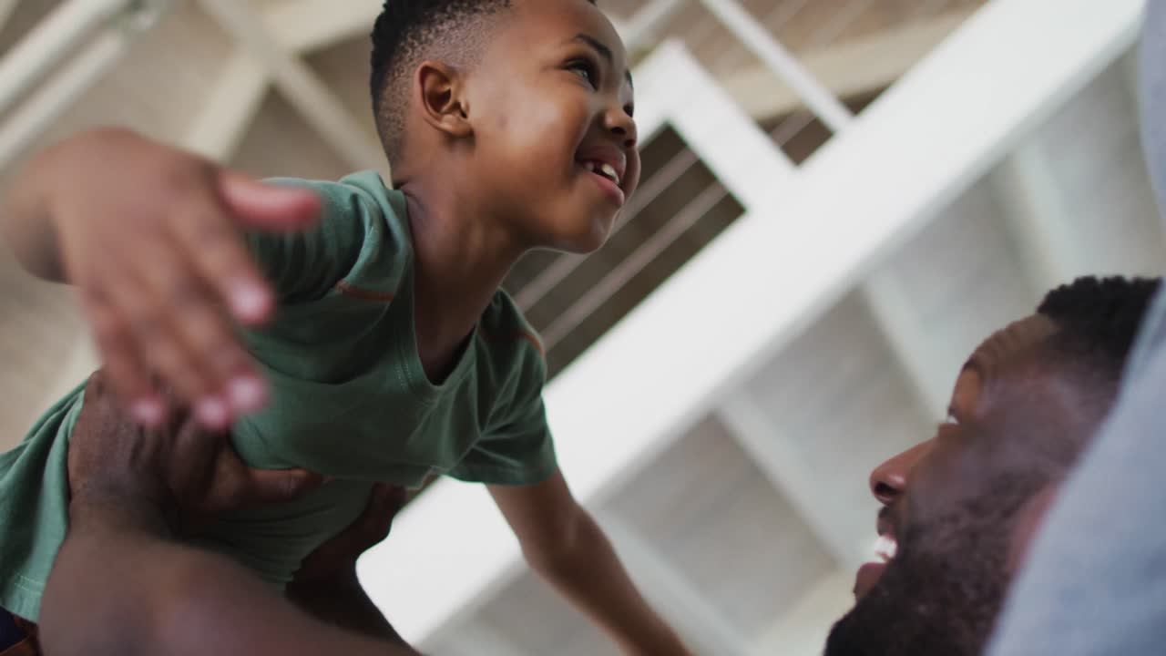 African american father and son playing together on the couch at home
