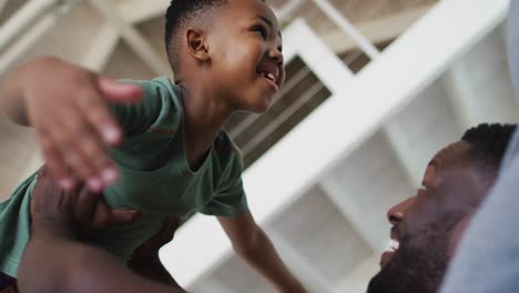 african american father and son playing together on the couch at home