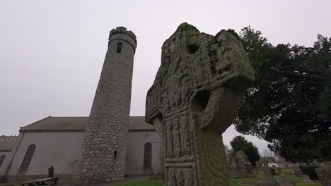 historic site castledermot kildare ireland high cross round tower churchyard and graves in winter