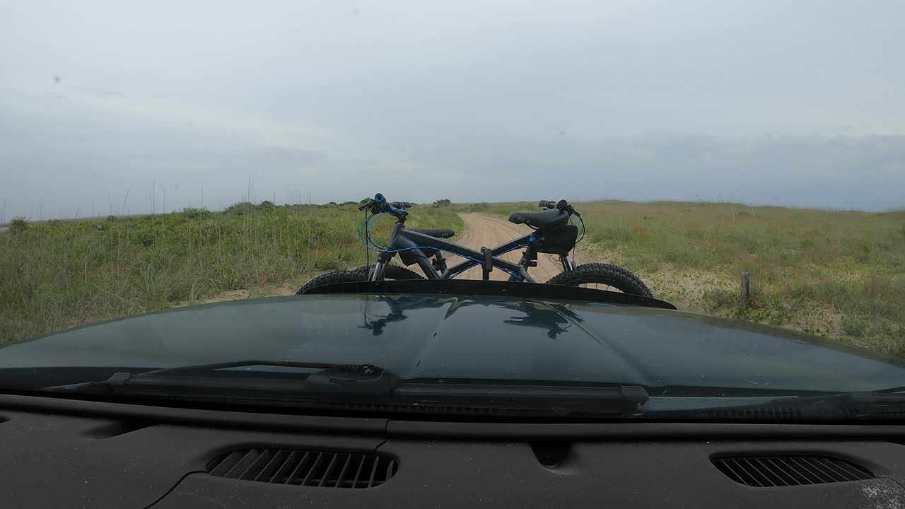 Dashboard Hyperlapse of an adventure seeking couple traveling along a shoreline and turning off into a twisty sand trail road