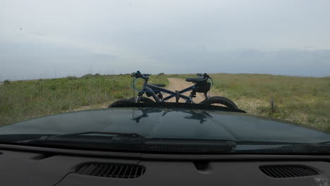 dashboard hyperlapse of an adventure seeking couple traveling along a shoreline and turning off into a twisty sand trail road