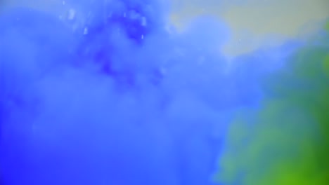 slow motion and close up underwater of blue and green water ink swirling around