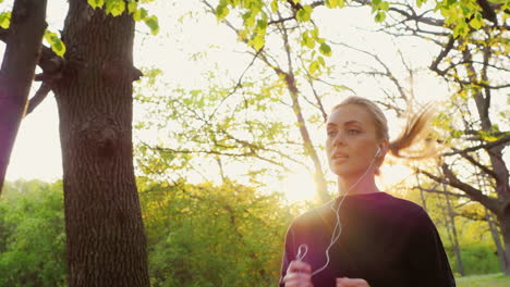 steadicam slow motion shot an attractive young woman makes a morning jog in the forest the sun is sh