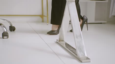 young girl is walking in the heels of her mother