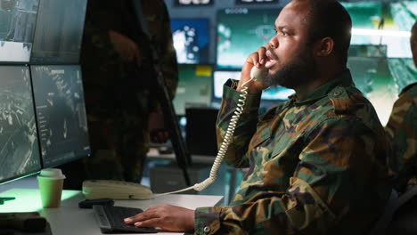 experto del ejército en llamada telefónica en la sala de monitoreo