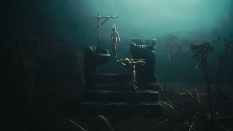a miniature scene of the mummified dolls hanging on the gallows at night
