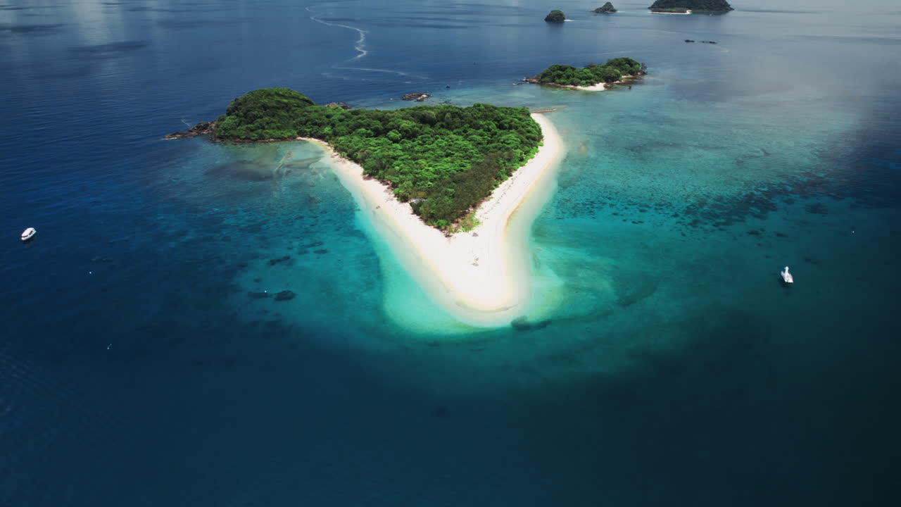 Ripresa aerea con drone che rivela un'isola tropicale, una laguna con barriera corallina poco profonda e la barriera corallina circostante alle Frankland Islands