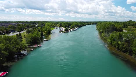 Vuelo-Aéreo-Hacia-Adelante-Sobre-El-Hermoso-Río-Rodeado-De-Botes-De-Estacionamiento-Durante-El-Día-Soleado-En-Las-Cataratas-Del-Niágara,-Estados-Unidos