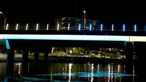 illuminated bridge reflecting on canal at night